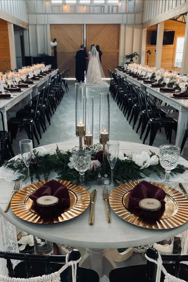 Bride walking the aisle between long candlelit tables