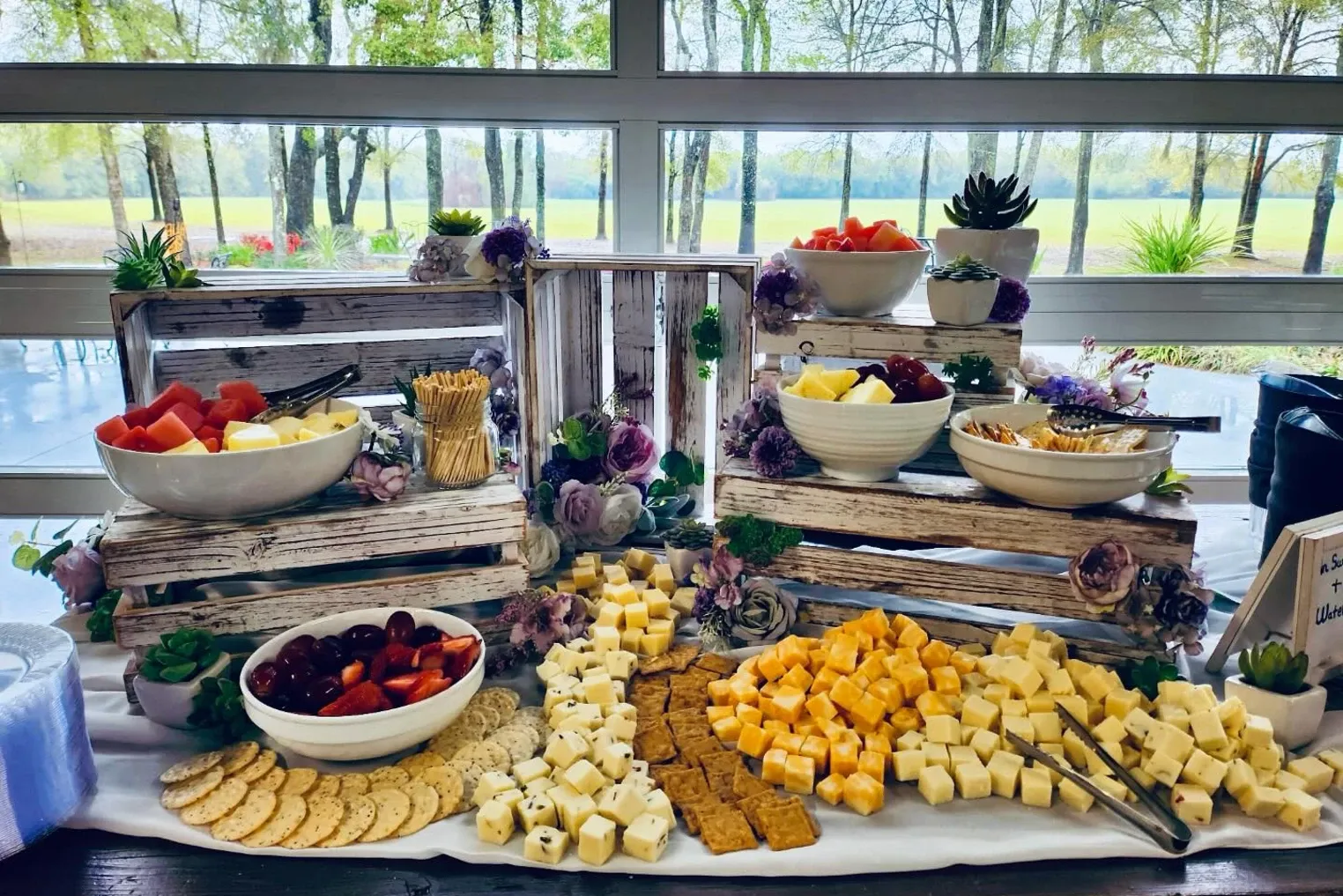 Grazing station on wooden crates with fruit, cheese, and crackers